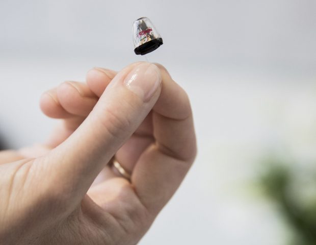 Invisible hearing aid in hand
