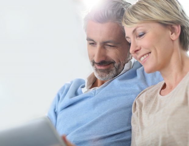Middle aged couple looking at laptop