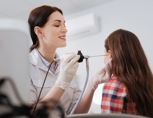 Audiologist Cleaning Young Girls Ear