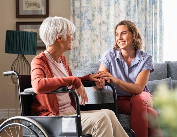 Mature woman comforting senior mom sitting on wheelchair