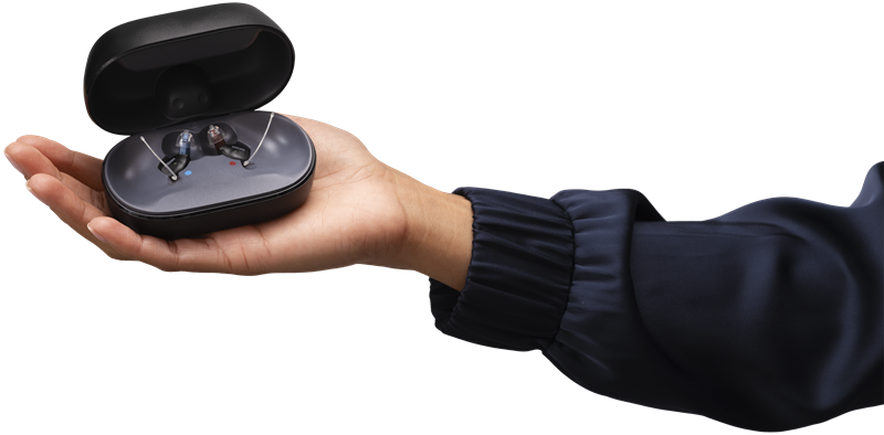 Oticon Zeal hearing aids and charger in hand